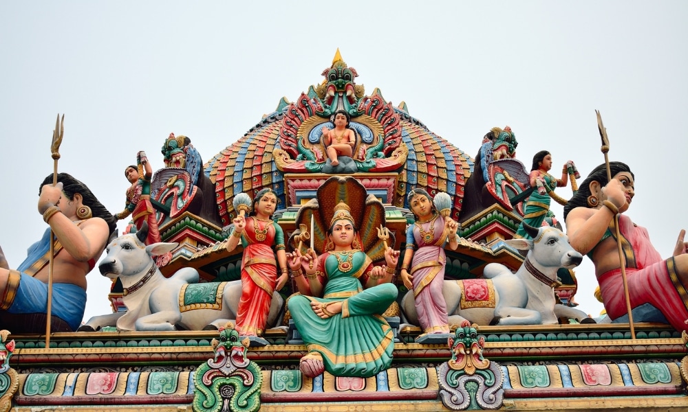 รูปปั้นสีสันสดใสและรายละเอียดประณีตของเทพเจ้าฮินดูและสัตว์ศักดิ์สิทธิ์ประดับอยู่บนหลังคาของวัดต่างประเทศแห่งนี้ ซึ่งตั้งอยู่อย่างงดงามตัดกับท้องฟ้า.